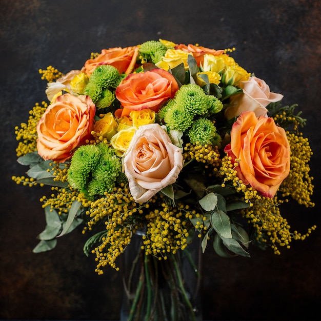オレンジ 黄色のバラ 暗い背景のミモザとバラの花束 無料の写真