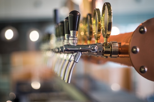 Premium Photo | Row of draft beer tab on the top of counter bar in ...