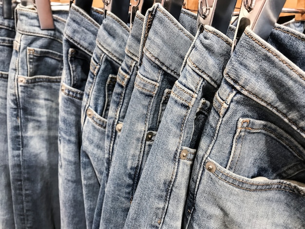 Premium Photo | Row of hanged blue jeans pants