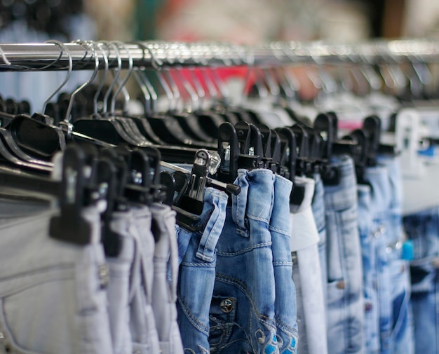 Premium Photo | Row of hanged blue jeans in a shop