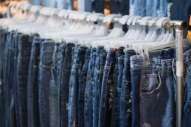 Premium Photo | Row of jeans and trousers on hangers for sale.