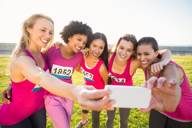 Premium Photo Runners Supporting Breast Cancer Marathon And Taking Selfies