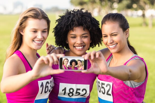 Premium Photo Runners Supporting Breast Cancer Marathon And Taking Selfies