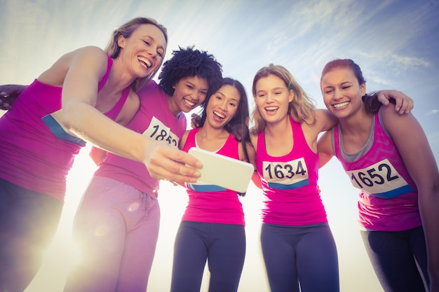 Premium Photo Runners Supporting Breast Cancer Marathon And Taking Selfies