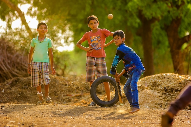 Premium Photo | Rural indian child playing cricket on ground