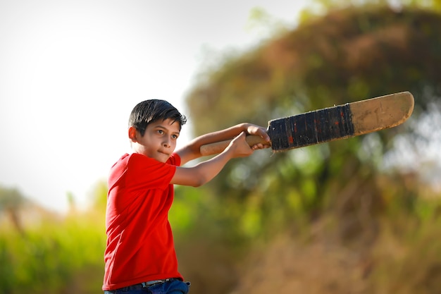 Premium Photo | Rural indian child playing cricket