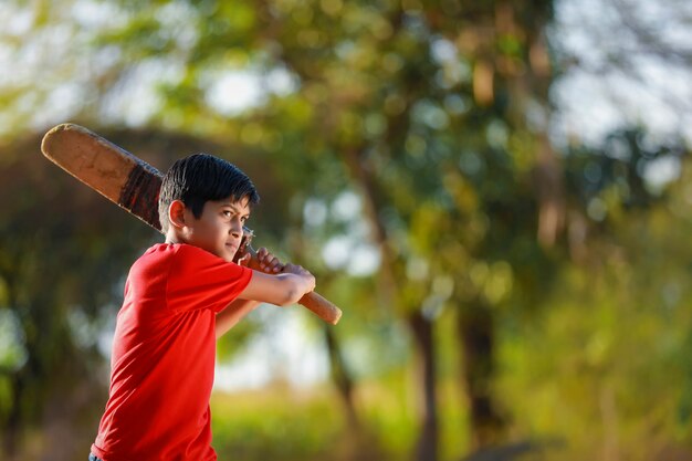 Premium Photo | Rural indian child playing cricket