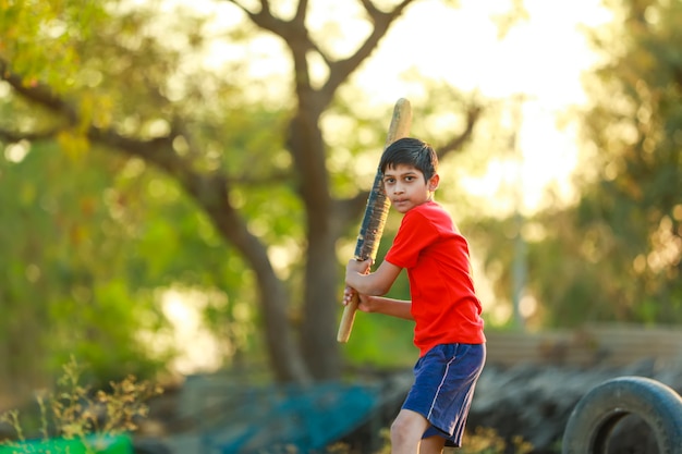 Premium Photo | Rural indian child playing cricket