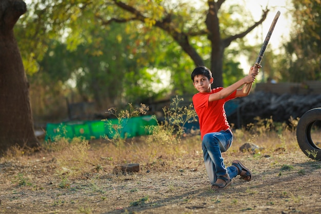 Premium Photo | Rural indian child playing cricket