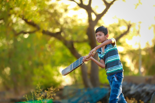 Premium Photo | Rural indian child playing cricket