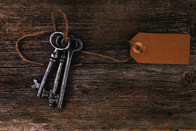 Rustic keys with label on wooden table Free Photo