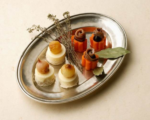 Premium Photo | Rustic tray with anchovies and cheese canapes