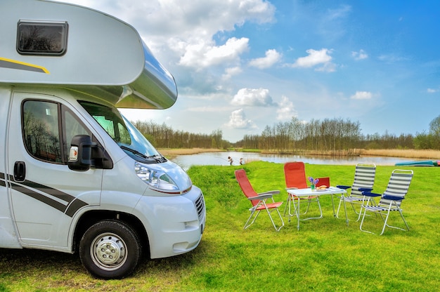 Premium Photo | Rv (camper) and chairs in camping