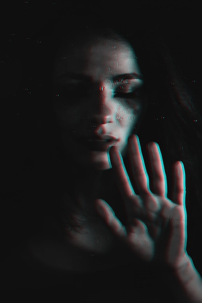 Sad girl with flowing mascara with glitch effect through the glass with  raindrops | Premium Photo
