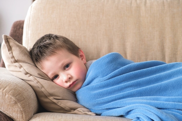 Premium Photo | A sad sick boy lying on the sofa at home under a blue ...