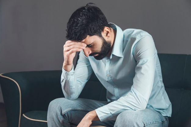 Premium Photo | Sad unhappy handsome man sitting on the sofa