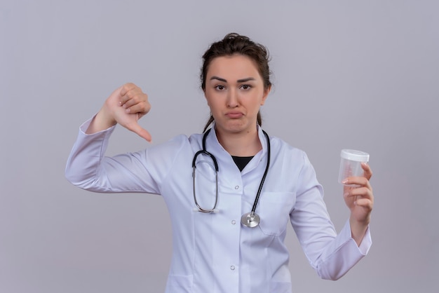 Free Photo Sad Young Doctor Wearing Medical Gown Wearing Stethoscope