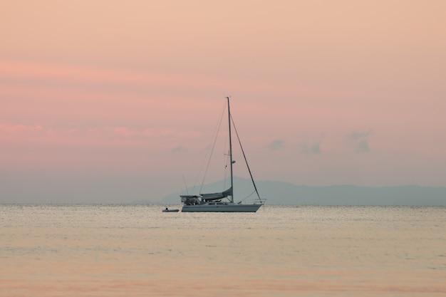 夏の背景と夕方に夕日の海でヨット プレミアム写真