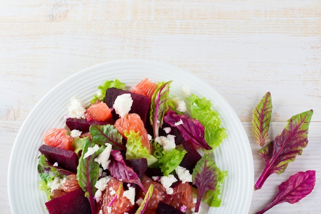 Premium Photo Salad Of Beets Lettuce Beetroot Leaves Grapefruit And Feta Cheese On A Light Surface