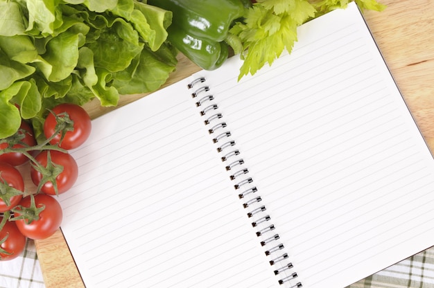 Premium Photo | Salad with blank recipe book and chopping board