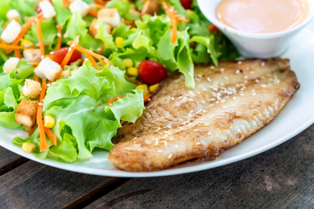 Premium Photo | Salad with fried fish fillet