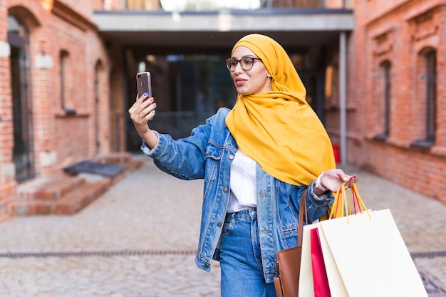 Premium Photo Sale Technologies And Buying Concept Happy Arab Muslim Woman Taking Selfie