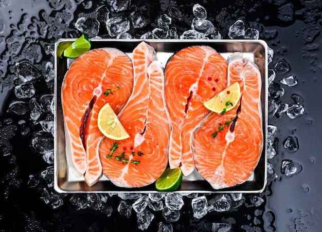 Salmon steaks on ice on black Premium Photo