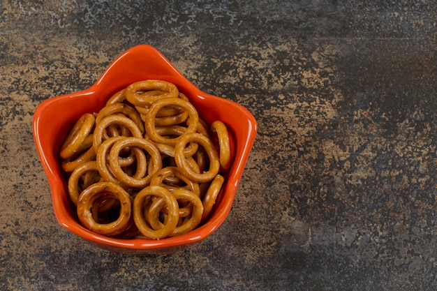 Free Photo | Salted circle pretzels in orange bowl.