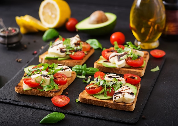 Premium Photo Sandwich Toasts With Tomatoes Mozzarella Avocado And Basil With Balsamic Vinegar