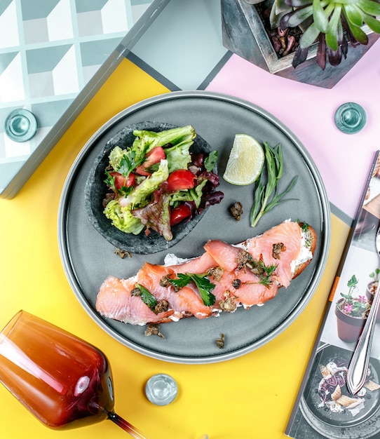 Sandwich with salmon and vegetables in the plate Free Photo