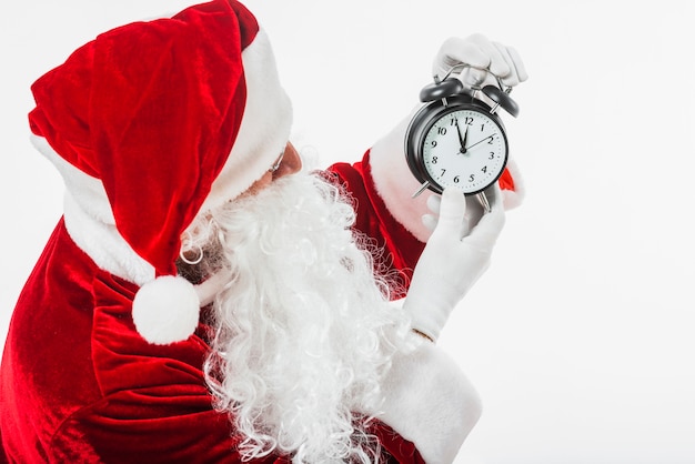 Santa claus looking at clock in hands | Free Photo