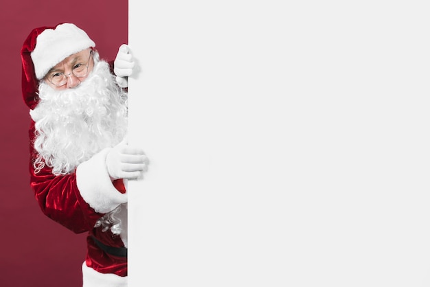 Santa Claus looking out of white wall  Photo | Free Download