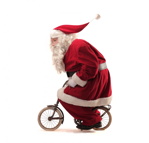 Download Santa claus riding a tiny bike Photo | Premium Download