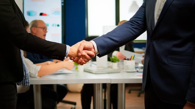 Satisfied businessman company employer wearing suit handshake new employee get hired at job interview, male hr manager employ successful candidate shake hand at business meeting, placement concept Free Photo