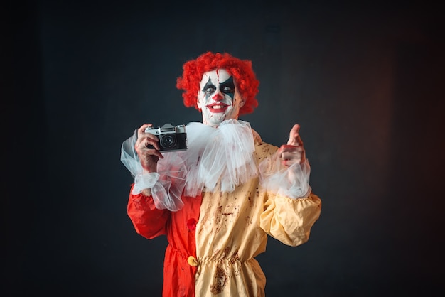 Premium Photo | Scary bloody clown with crazy eyes makes picture