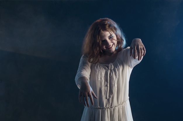 暗闇の中でホラー映画から白いドレスで怖い女の子 プレミアム写真