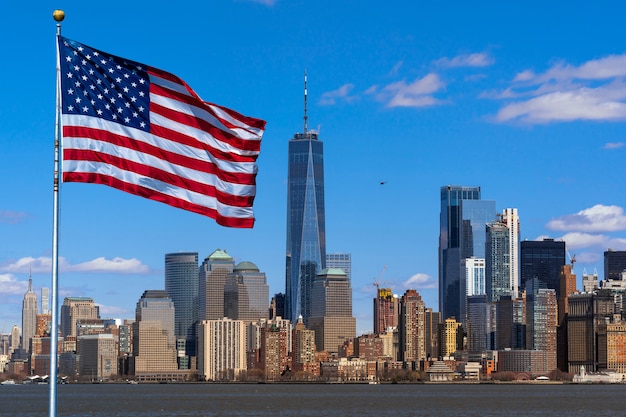 所在地がマンハッタンのニューヨークの街並み川沿いのアメリカ国旗の光景 プレミアム写真