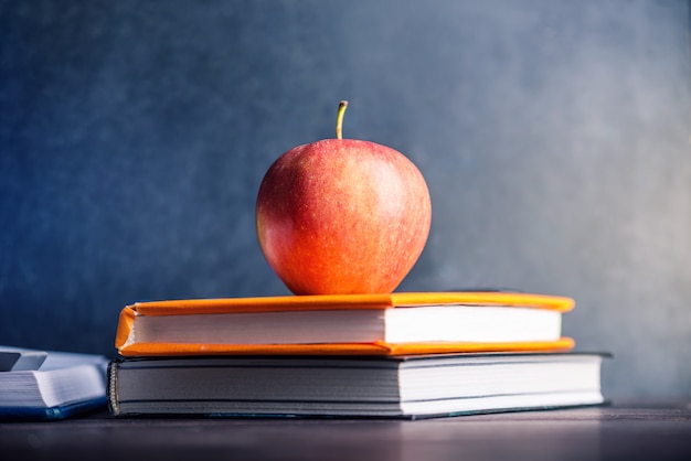 School supplies on the table. books and apples is a collection of the student. Premium Photo
