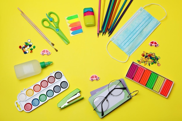 Premium Photo | School supplies on yellow surface