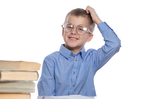 Premium Photo | A schoolboy with glasses sits at a table and laughs ...