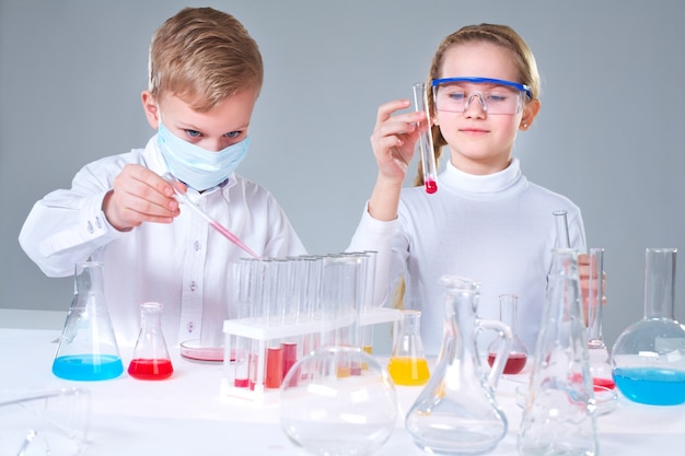 Schoolchildren mixing liquids Free Photo