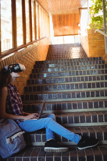 階段で仮想現実のヘッドセットとラップトップを使用して女子高生 プレミアム写真