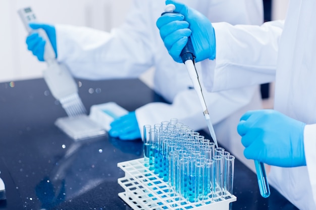 Premium Photo | Science students using pipettes to fill test tubes