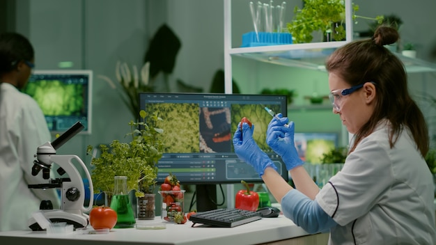 Premium Photo | Scientist injecting strawberry with pesticides ...