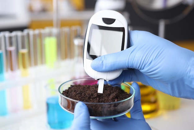 Scientist with gloves measures soil readings in test tube Premium Photo