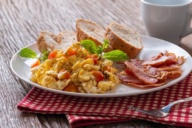 Premium Photo | Scrambled egg with tomato sliced, bacon grill and ...