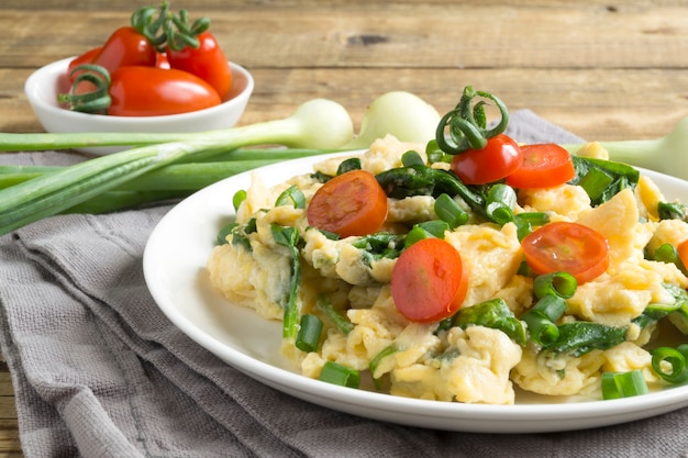 Premium Photo Scrambled Eggs With Spinach And Tomatoes On A White Plate