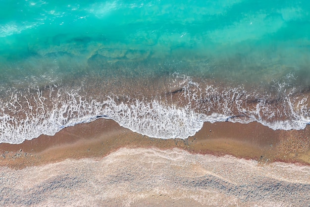 Premium Photo | Sea waves breaking on a yellow sand shore, top view ...