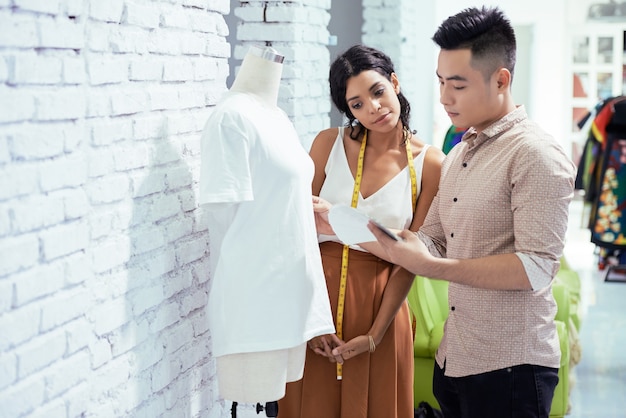 Premium Photo | Seamstress and fashion designer checking sample of ...