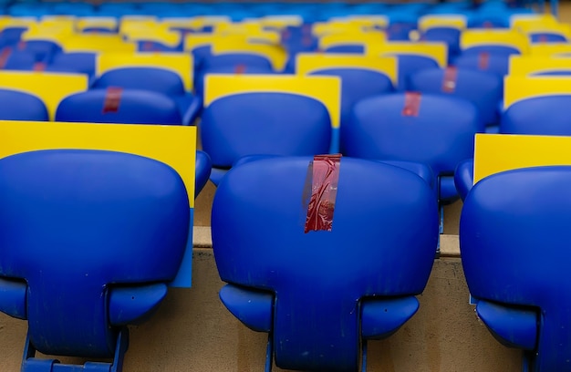 premium-photo-seats-in-a-football-stadium-during-a-pandemic-through-one-taped-to-keep-distance